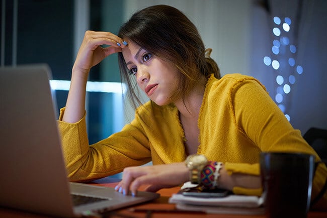 Businesswoman looks despondently at her laptop because her systems are disconnected