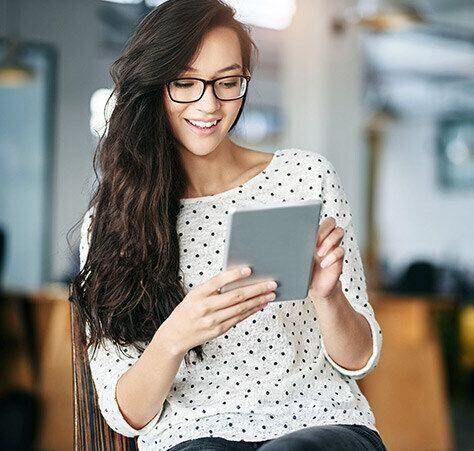Smiling businesswoman uses a tablet in an office building