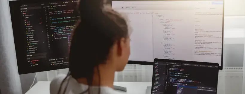 Woman looking at computer monitors for Managed IT Services