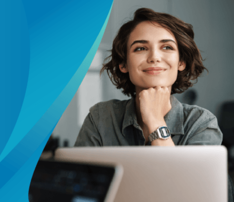 Businesswoman smiles while looking over her laptop