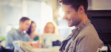 Smiling young man using digital tablet in the office-1-1