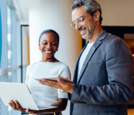 Businessman and businesswoman look at SAP Business AI on the man's tablet while the woman holds a laptop