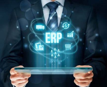 A businessperson holds a tablet with 'ERP' and graphics for money, data, shopping, and business growth hovering above it