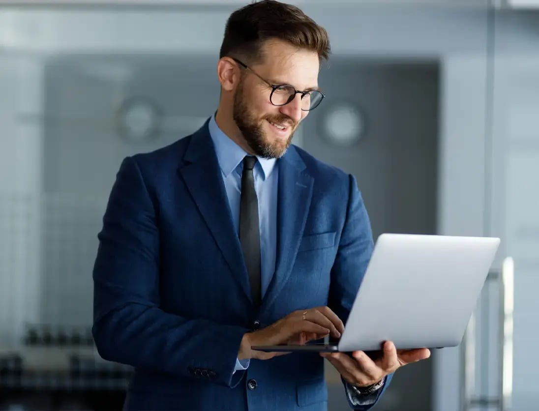 Businessman looks at his laptop in the office to implement copilot for SAP Business One