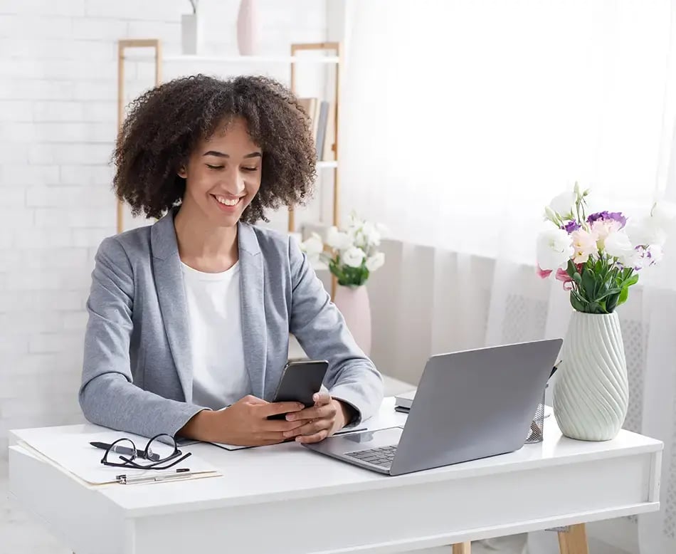 Happy woman texting on her phone to her boss that the Hubspot integration was a success