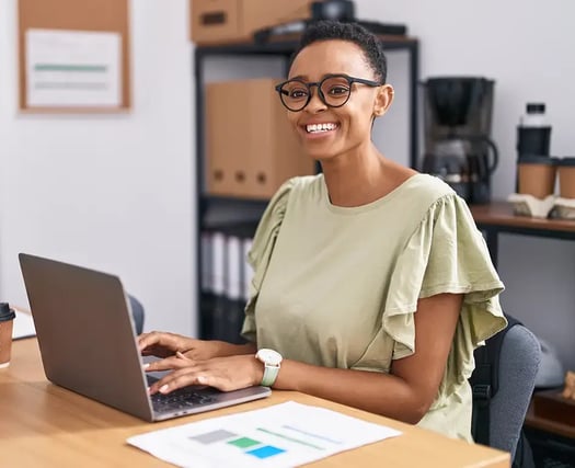 Smiling business woman works on her Hubspot and Saltbox Integration from her laptop