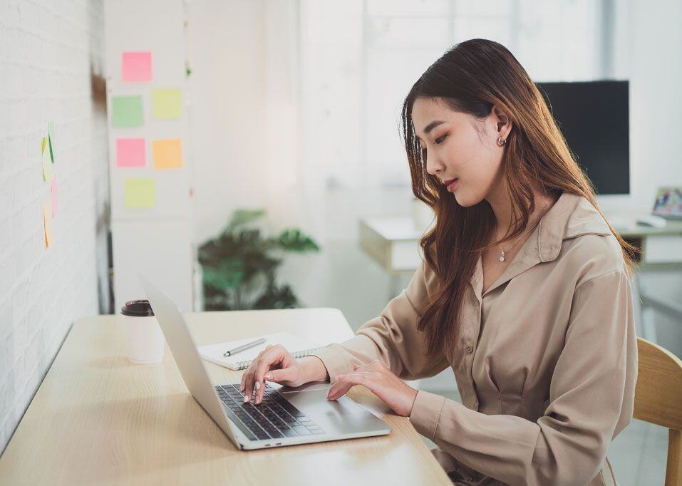 Une femme d'affaires examine des données sur un écran d'ordinateur dans son bureau