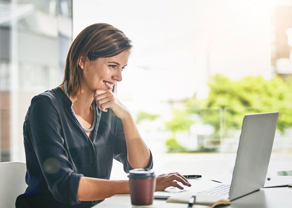 Femme d'affaires souriante sur un ordinateur portable
