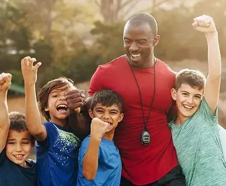 A group of children and a coach celebrating success with Sage Intacct