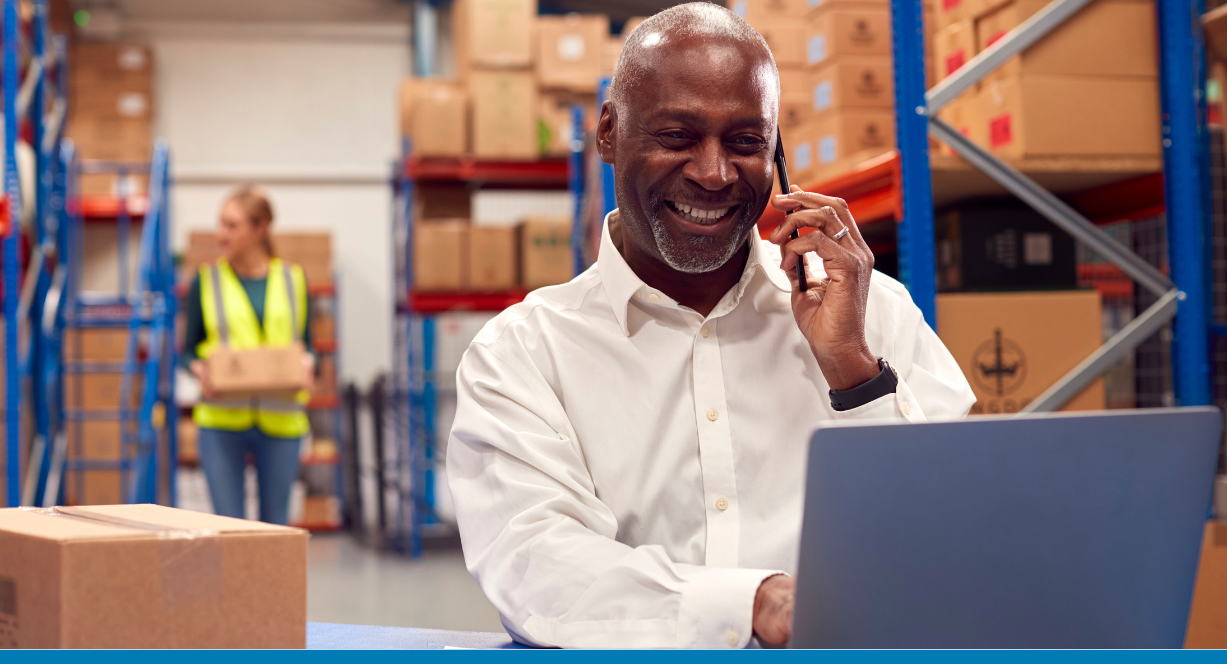 A businessman in a modern warehouse running SAP S/4HANA Cloud Public Edition for distribution